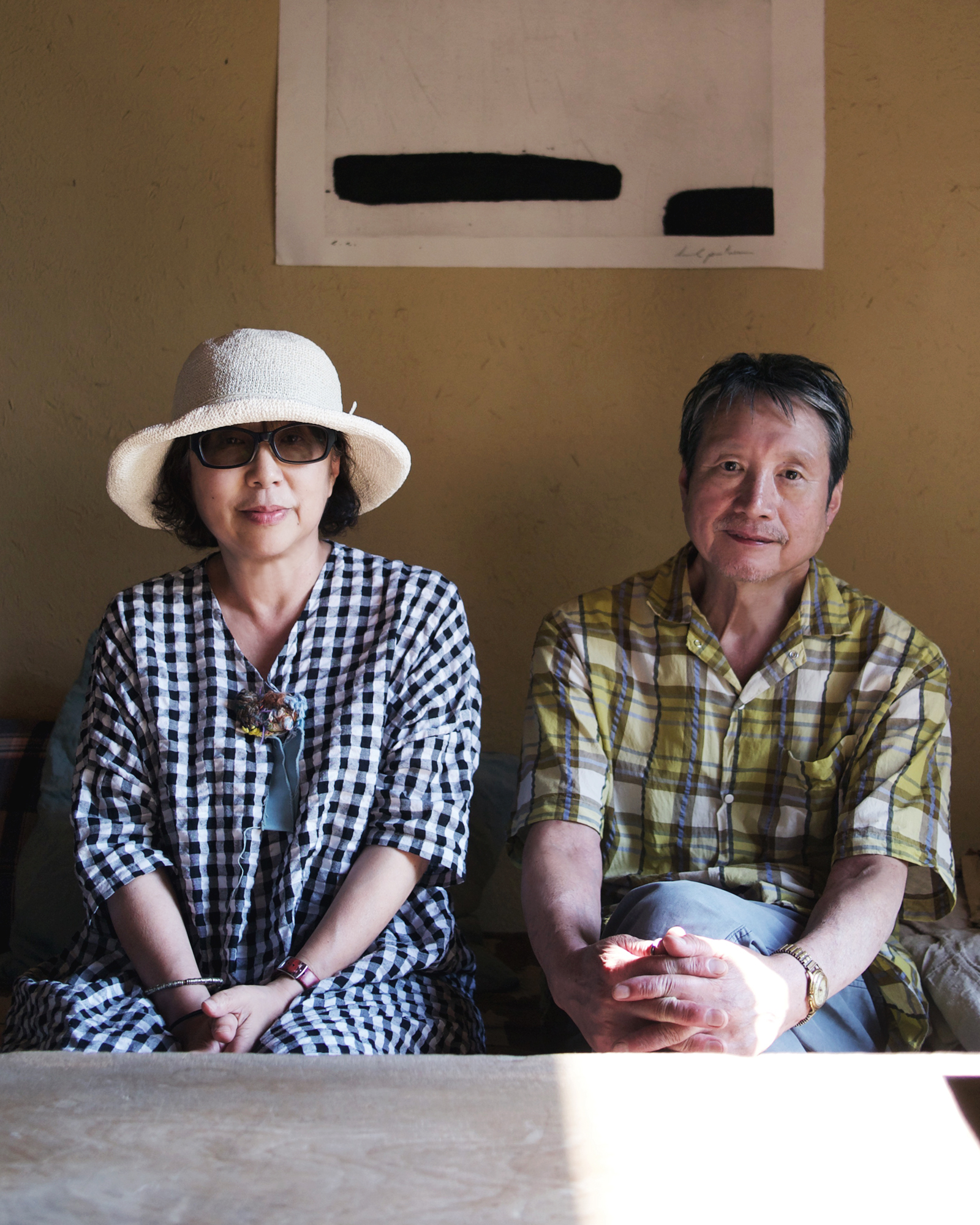 Michiko Iwata and Keisuke Iwata sitting side by side at their home in Fukuoka