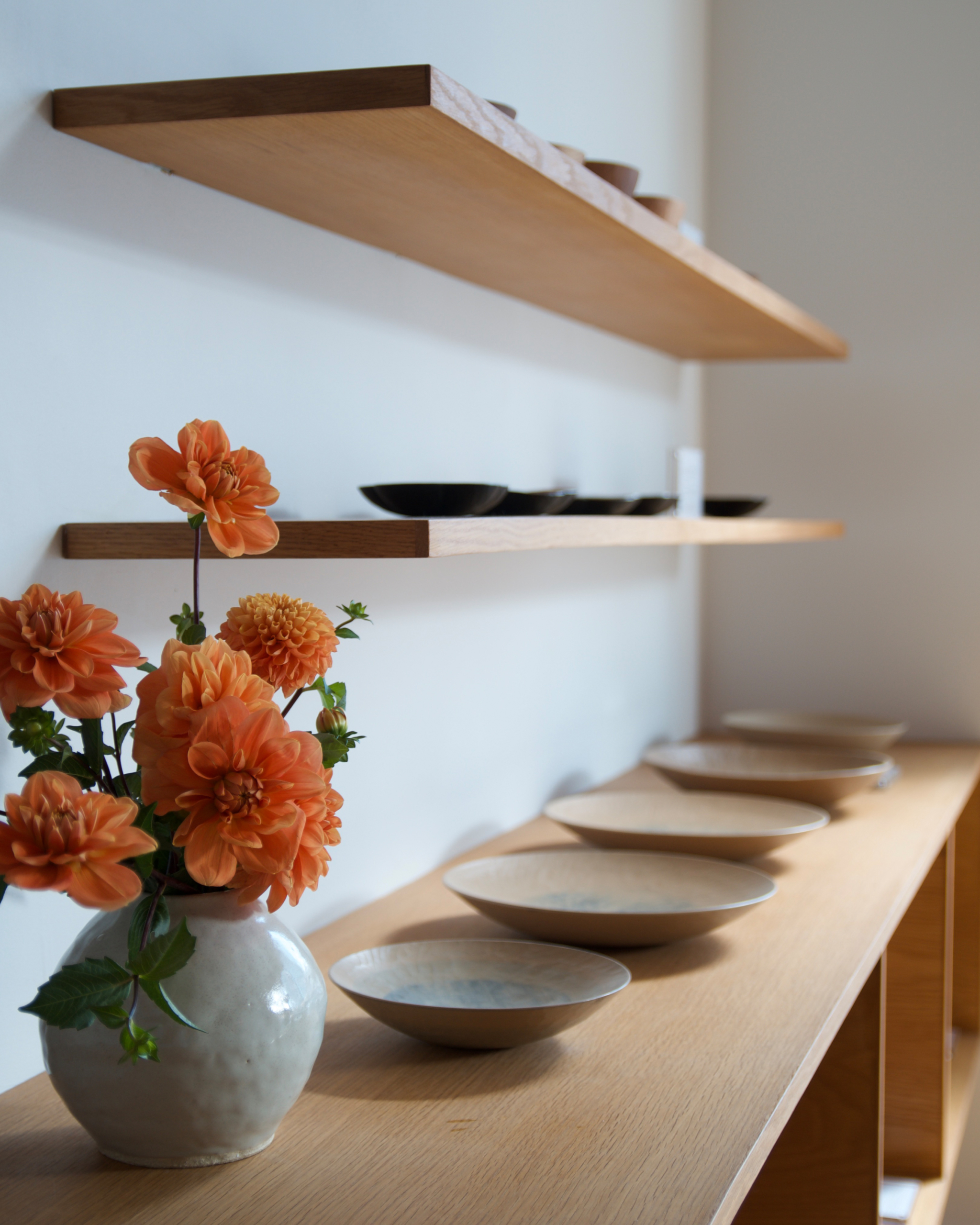 Dani Sujin Moon Vase beside white wooden bowls by Ryuji Mitani