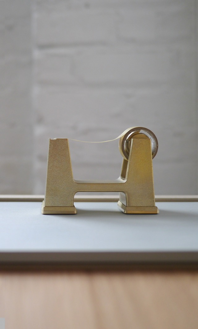 Brass tape dispenser on a desk
