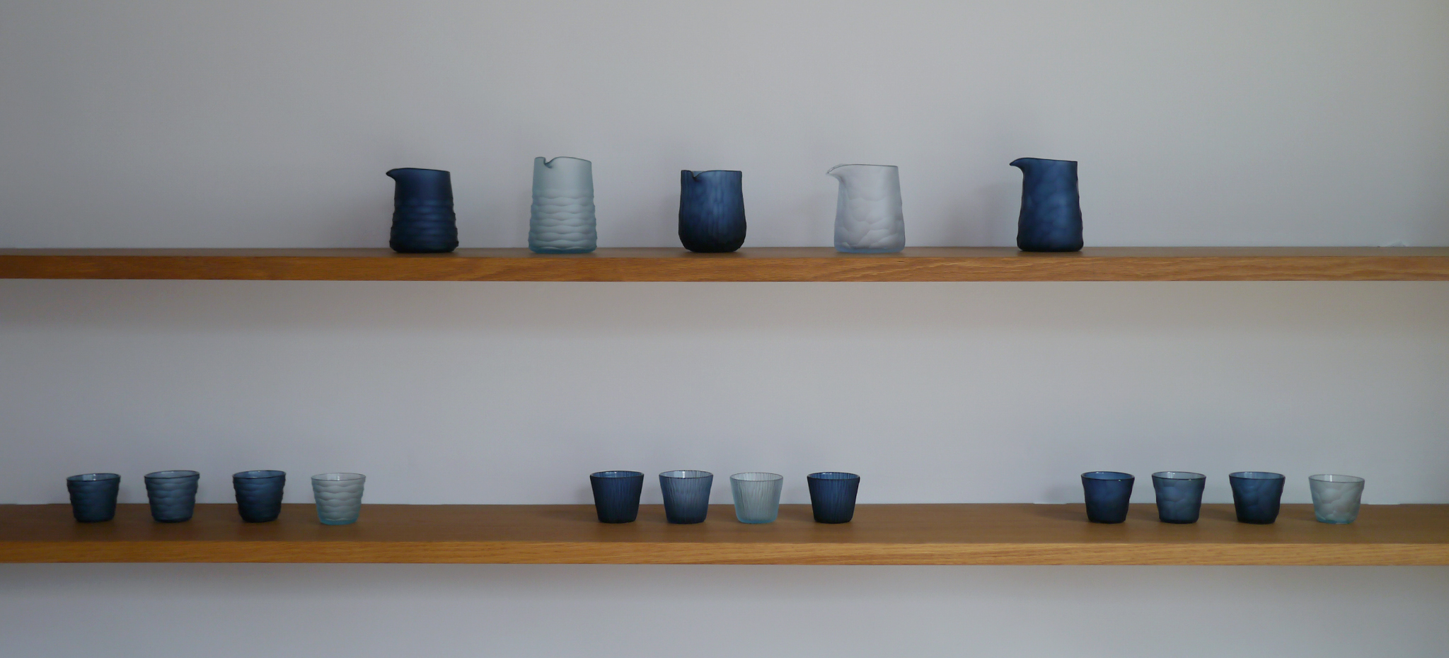 factory zoomer carved reclaimed blue pitchers and cups on a shelf