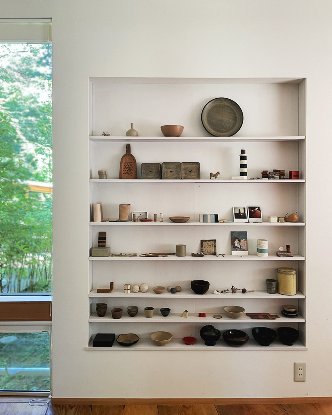 Shelves at Ryuji Mitani's studio that hold various wood art and tableware