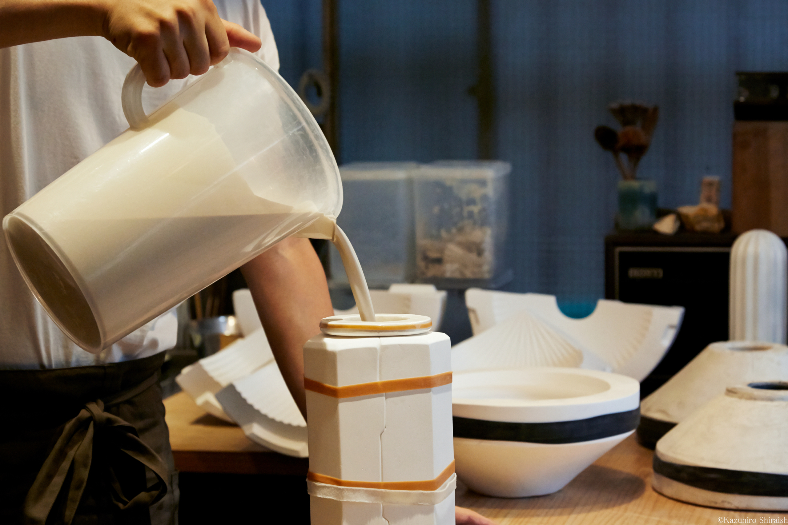 Hirotake Tobimatsu pouring porcelain mixture into split mold porcelain casts at the Tobimatsu Toki studio