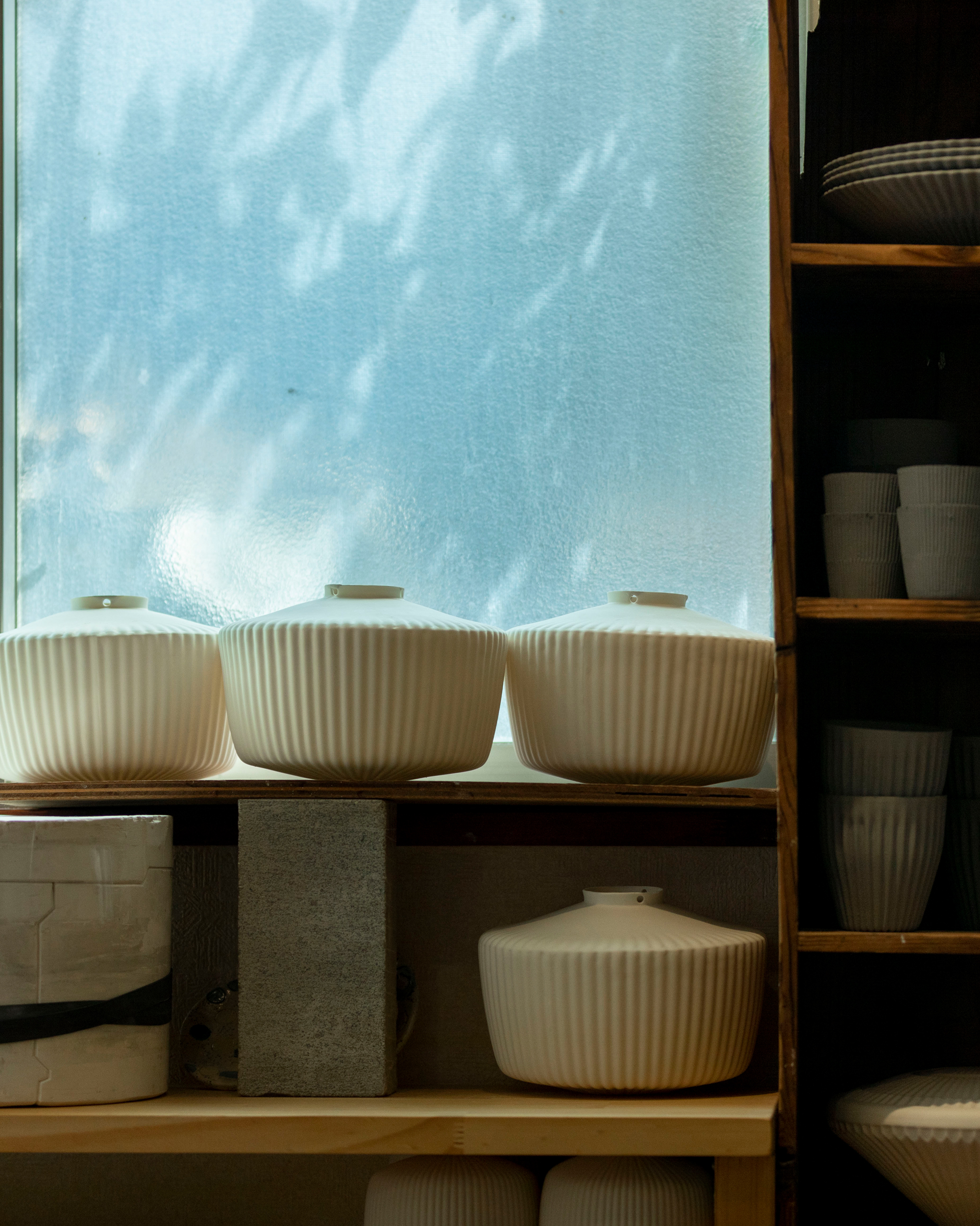 porcelain shades resting on a shelf at Tobimatsu Toki's studio