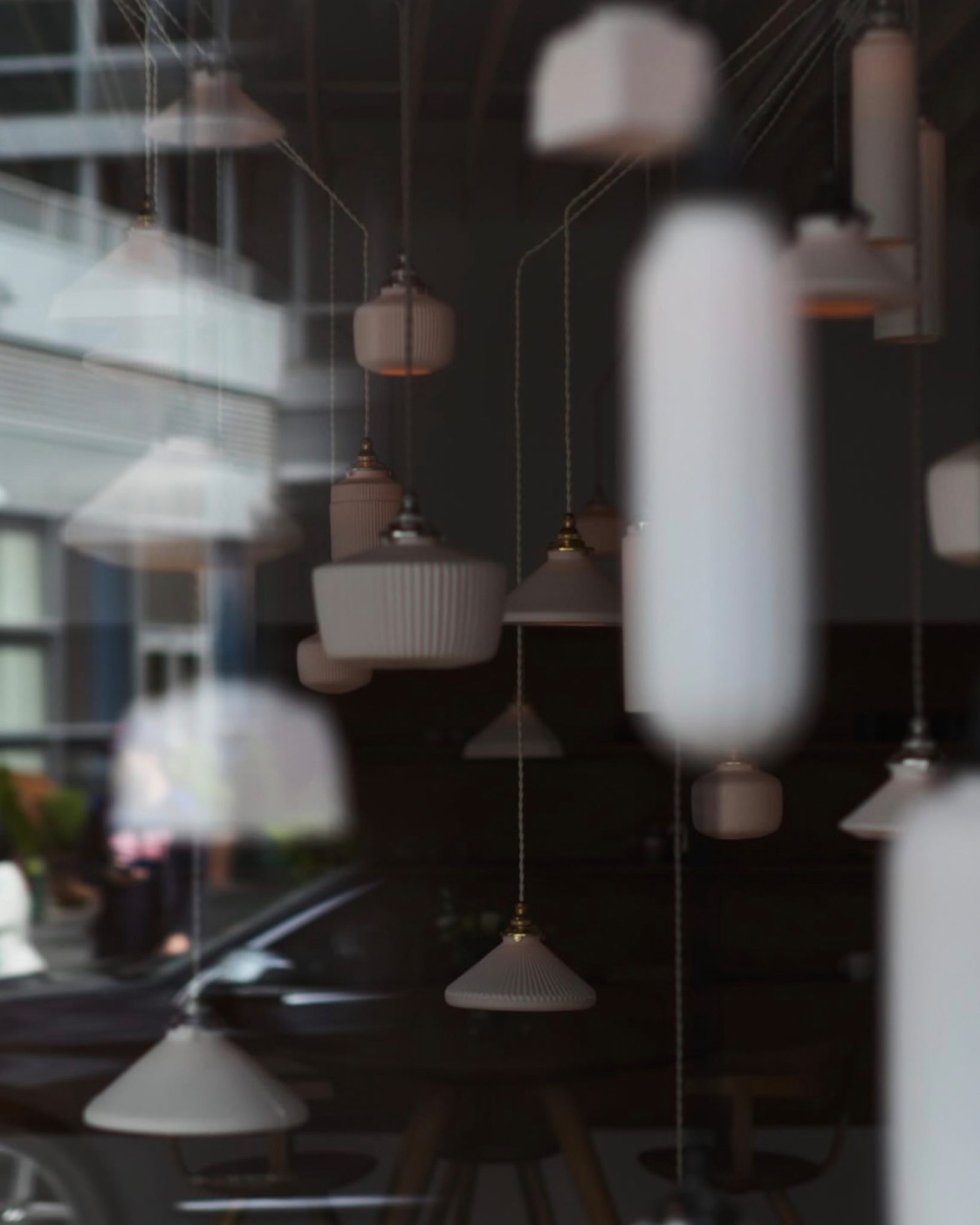 ethereal image of reflections of Tobimatsu hanging pendants from outside and through Nalata Nalata gallery windows