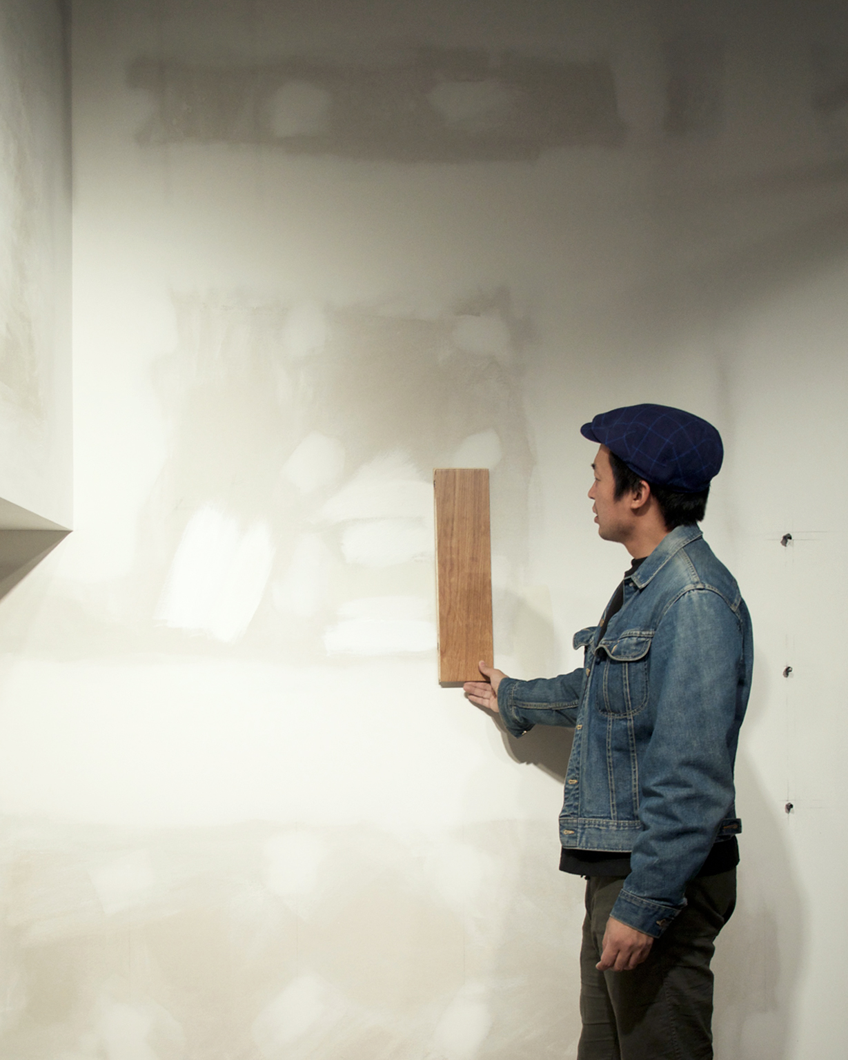 Stevenson comparing wood with a white oak panel on the wall