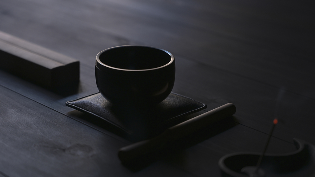 Close up of Nezen Iwata sound bowl on a pad in a dark floored room