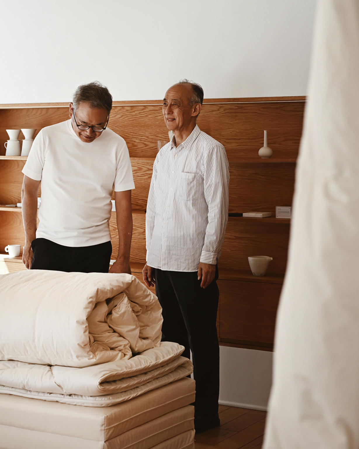 Arichika Iwata standing with team behind futon set and duvet by Iwata