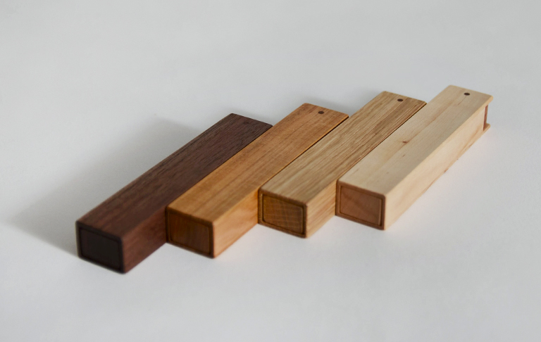 Row of wood pocket toothpick cases by Tanno in walnut, cherry, oak and maple
